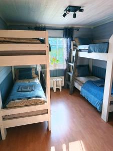 a room with three bunk beds and a window at Northern Dream Lofoten in Hovdan