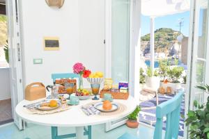 a white table with food on it on a balcony at Chiaia Di Rose Seaside Suite in Sant'Angelo D'Ischia