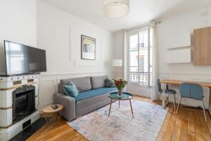 una sala de estar con un sofá y una mesa en Arc de Triomphe Magnifique appartement, en París