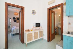 a room with a television and a room with a bathroom at Chiaia Di Rose Seaside Suite in Sant'Angelo D'Ischia