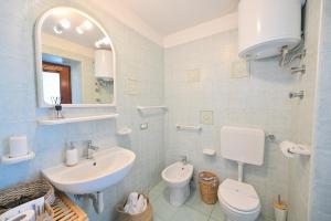 a bathroom with a sink and a toilet and a mirror at Chiaia Di Rose Seaside Suite in Sant'Angelo D'Ischia +28 photos