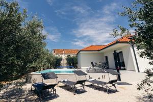 a patio with chairs and a swimming pool at Martha's Oliveyard in Biograd na Moru