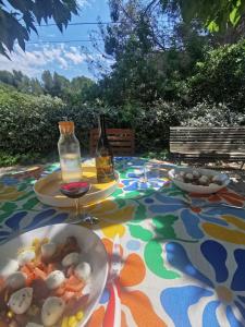 a table with a bowl of food and a bottle of wine at Les Mûriers in La Ciotat +4 photos