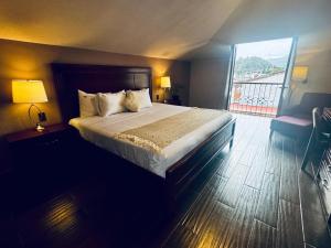 a bedroom with a large bed and a large window at Parador Margarita in San Cristóbal de Las Casas