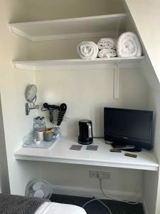 a desk with a computer monitor on a shelf at Black Swan Hotel in Kelso