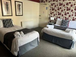 a hotel room with two beds with towels on them at Black Swan Inn in Kelso