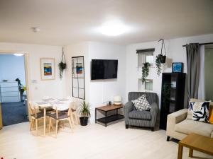 ニューキーにあるModern surf pad, steps from Towan beachのソファとテーブルと椅子のあるリビングルーム
