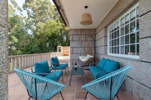 a patio with blue chairs and a table at Villa Cies con Piscina in Vigo