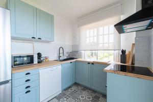 a kitchen with blue cabinets and white appliances at Villa Cies con Piscina in Vigo