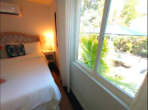 a bedroom with a bed and a large window at Romantic Tropical Retreat with a Private Hot Tub! in Long Beach