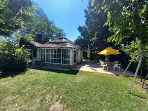 a garden with a conservatory with a yellow umbrella at NEWEN POSADA in La Consulta