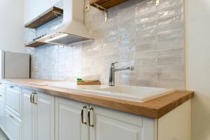 a kitchen with white cabinets and a sink at Aparthotel Pils 17 in Ventspils +91 photos