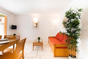 a living room with a red couch and a table at Appartement 52 4-6 personnes plages à pied in Capbreton
