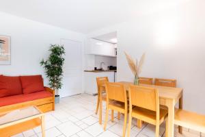 a kitchen and dining room with a table and chairs at Appartement 52 4-6 personnes plages à pied in Capbreton +35 photos