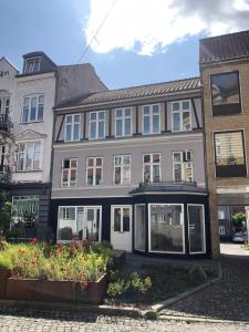a large house with windows and flowers in front of it at Slotsgaarden ved Hesten in Randers