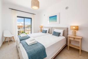 a bedroom with two beds and a balcony at Casa Palmeira in Lagos +58 photos