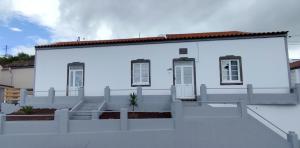 a white house with a fence in front of it at Azure Vista Lodge in Nordestinho
