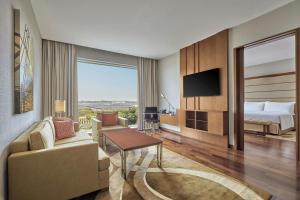 a hotel room with a bed and a living room at Courtyard by Marriott Kochi Airport in Nedumbassery