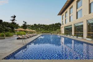 a swimming pool in front of a building at Courtyard by Marriott Kochi Airport in Nedumbassery