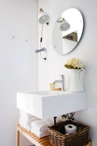 a bathroom with a white sink and a mirror at Sparrow Sintra Nest in Sintra