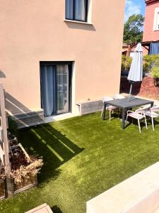 a backyard with a table and chairs and a lawn at Désirée in Le Bosc +3 photos