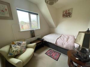 a bedroom with a bed and a chair and a window at Room in Dublin