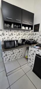 a kitchen with black and white tiles on the wall at Suite in Arraial do Cabo in Arraial do Cabo +8 photos