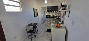 a kitchen with a refrigerator and a small table at Suite in Arraial do Cabo in Arraial do Cabo