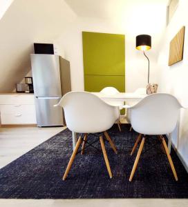 a kitchen with a table and two white chairs at Flair Apartments 'FACHWERK & FLAIR' - Altstadt-Apartment 78 qm für Urlaub oder Geschäftsreise, Innenstadtlage, ruhig, modern, 900 m Bahnhof, 24 Std Check-in, WLAN, Streaming, Küche, Regendusche, 2 x Doppelbett, direkt am neuen Markt in der Altstadt in Herford +29 photos