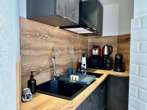 a kitchen with a sink and a microwave at Le Perchoir-WIFI-Face à la Gare-Terrasses-Proche tous commerces in Sarrebourg