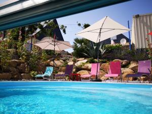 a group of chairs and umbrellas next to a swimming pool at Meeresbrise in Loperhet +15 photos