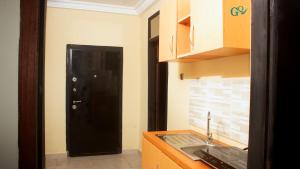 a kitchen with a black door and a sink at CARL's VILLA APARTMENTS in Accra +6 photos