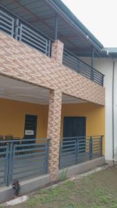 a house with a balcony with blue railings on it at CARL's VILLA APARTMENTS in Accra