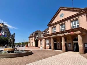 a building with a fountain in front of it at Le Perchoir-WIFI-Face à la Gare-Terrasses-Proche tous commerces in Sarrebourg