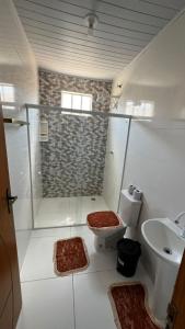 a bathroom with a shower and a toilet and a sink at Casa da Val in Conceição da Barra