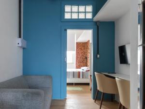 Habitación con paredes azules, mesa y sillas. en Apartamento com Ar-Condicionado, en Salvador