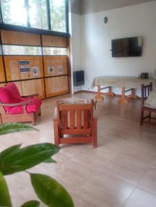 a room with chairs and a table and a tv at Quincho Coihues in Esquel