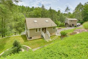 a small green house on a grassy hill at Shohola Creek On-Site Updated Getaway with Deck! in Shohola