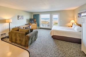 a hotel room with a bed and a couch at 107 Ocean Picture Academy - Beachfront Condo - Pool Hot Tub & Full Kitchen in Lincoln City