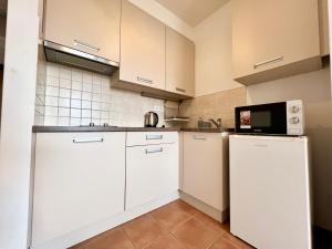 Una cocina con gabinetes blancos y un microondas. en Budapest Citylink Aparthotel, en Budapest