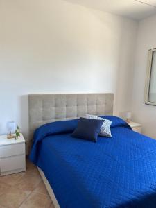 a bed with a blue comforter in a bedroom at La Finestra Sul Mare in Tusa