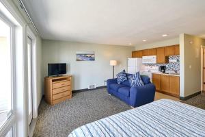 a bedroom with a bed and a blue couch and a kitchen at Oceanfront Studio - Ground Floor - King Bed - Easy Beach Access - Pool & Hot Tub in Lincoln City +19 photos