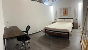 a bedroom with a bed and a desk and a table at 150m from the beach in Barcelona