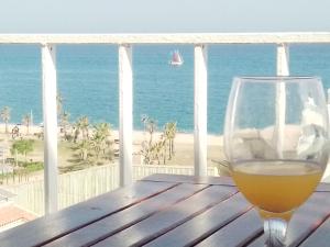 a glass of wine sitting on a table on the beach at terraza al mar in Pineda de Mar
