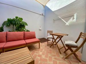 a living room with a red couch and a table at Oliva Lofts & Beach in Oliva