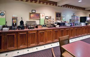 a restaurant with a long counter with wooden cabinets at Country Inn & Suites by Radisson, Columbia, SC in Columbia