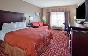 a hotel room with a bed and a chair and a television at Country Inn & Suites by Radisson, Columbia, SC in Columbia