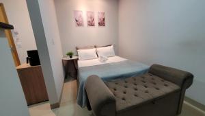 een kleine slaapkamer met een bed en een stoel bij Residencial Hanna in Anápolis