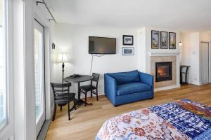 a bedroom with a bed and a blue chair and a fireplace at Ground Floor Condo - Ocean View - Pool & Hot Tub in Lincoln City