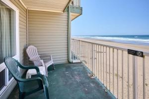 a balcony with two chairs and the beach at Ground Floor Condo - Ocean View - Pool & Hot Tub in Lincoln City